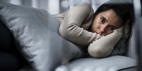 Depressed woman laying on a couch
