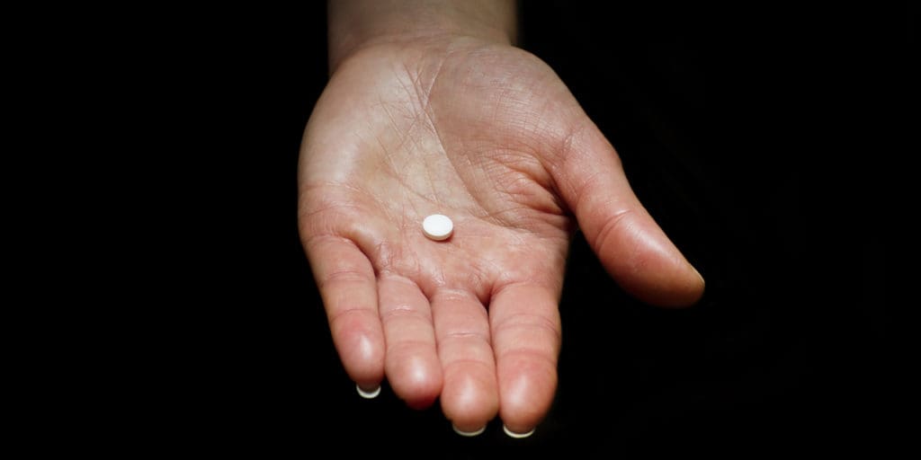 Hand holding a pill
