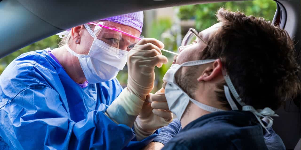 Medical staff administering a COVID-19 test