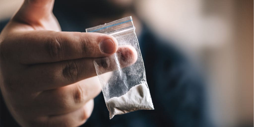 Man holding bag of cocaine