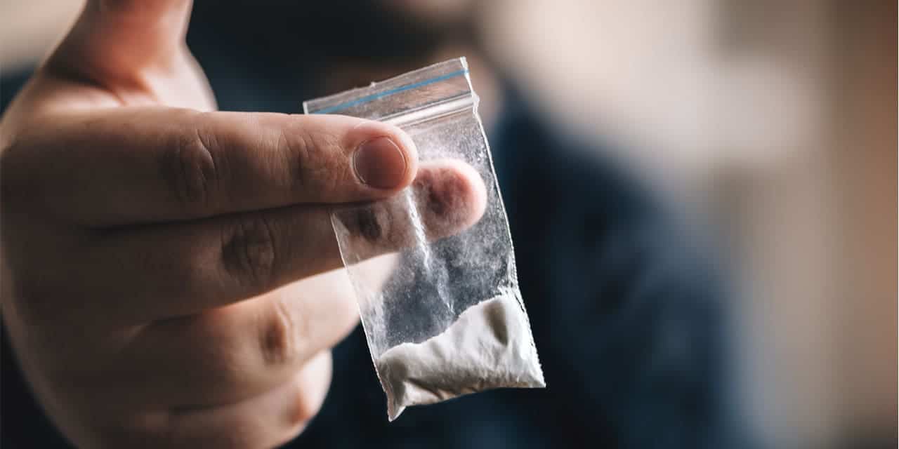 Man holding bag of cocaine