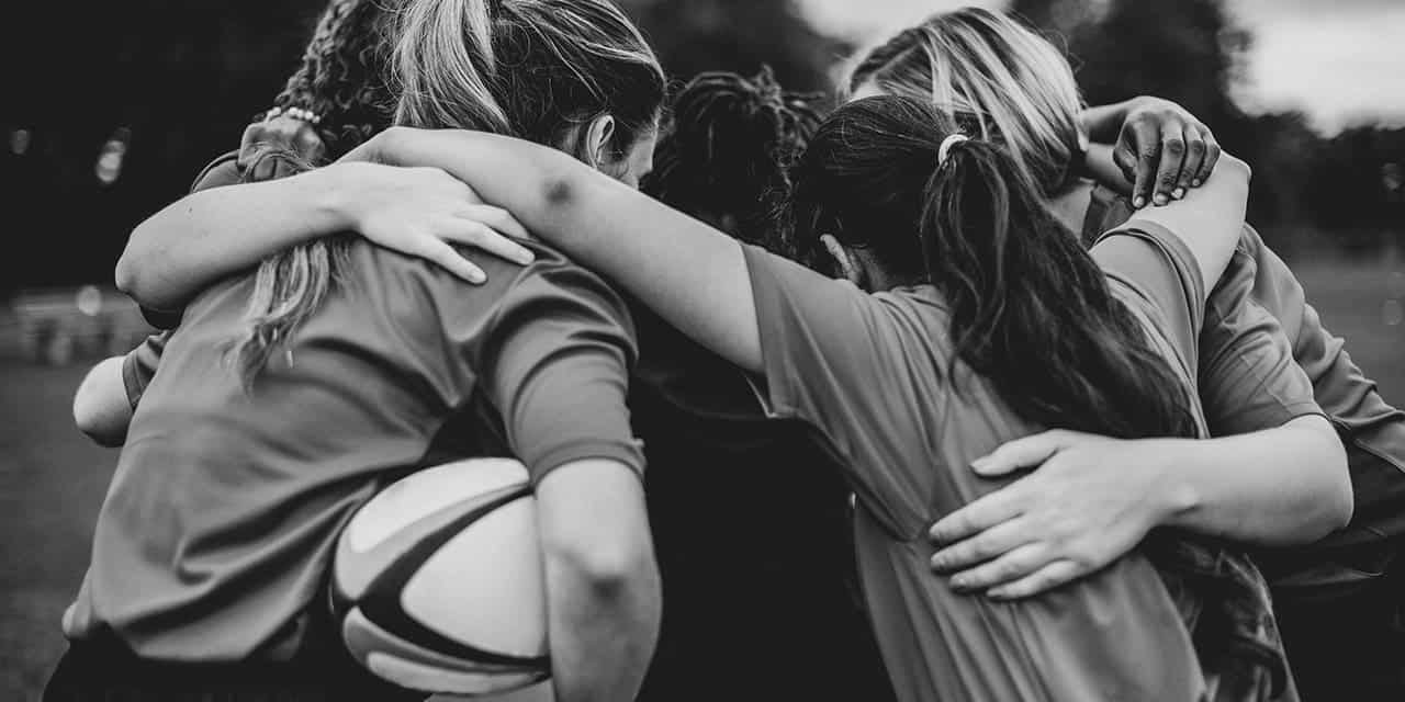 Girls doing a chant before their sports game