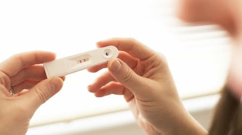A women holding a positive pregnancy test